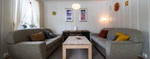Stue med malt Skjåkpanel i furu der det er brukt brede furubord